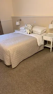a bedroom with a large bed with a night stand at Hunters Meet in Bishops Stortford