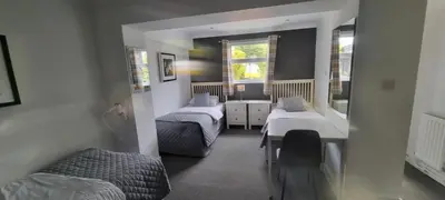 a small room with two beds and a window at Hunters Meet in Bishops Stortford