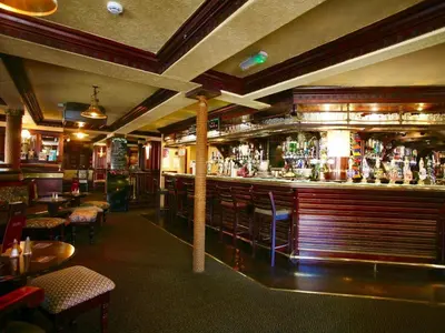 a bar in a restaurant with tables and chairs at The Ship in Chelmsford