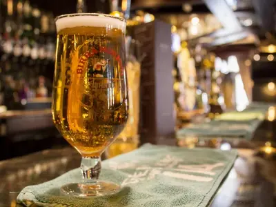 a glass of beer sitting on top of a bar at The Ship in Chelmsford