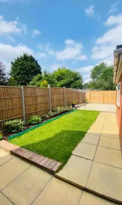 a backyard with a fence and green grass at Hawtհorn Guestհouse in Cambridge