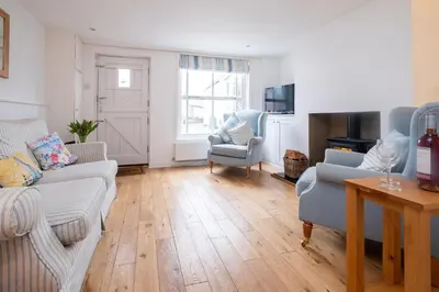 a living room with a couch and chairs and a television at Puddleduck Cottage in Aldeburgh