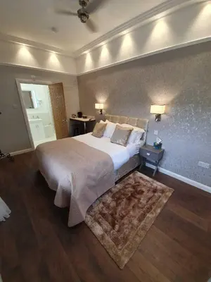 a bedroom with a large bed and a rug at Old Thatch Bambers Green in Takeley