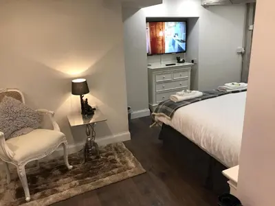 a bedroom with a bed and a desk and a television at Old Thatch Bambers Green in Takeley