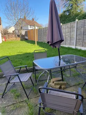 a table and two chairs and an umbrella at By Buildersbeds - Hill House 3 Bedrooms in Romford