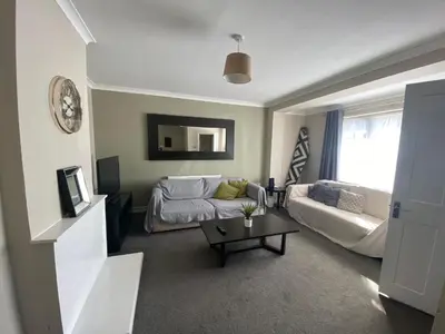 a living room with a couch and a table at By Buildersbeds - Hill House 3 Bedrooms in Romford