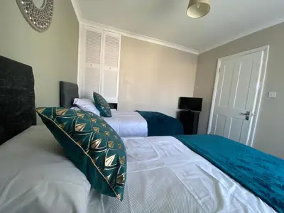 a bedroom with two beds with blue and white at By Buildersbeds - Hill House 3 Bedrooms in Romford
