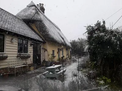 a picnic table in front of a house in the snow at Ivy Todd cottage in Debden