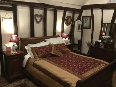 a bedroom with a large bed and two night stands at Ivy Todd cottage in Debden