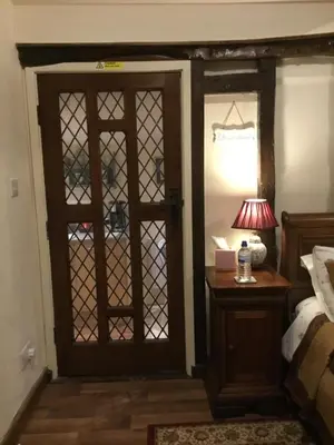 a room with a door and a table with a lamp at Ivy Todd cottage in Debden