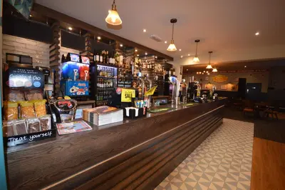 a bar in a restaurant with a counter and drinks at Camping Pods, Carlton Meres Holiday Park in Rendham