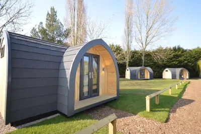 a tiny house with a large window on the grass at Camping Pods, Carlton Meres Holiday Park in Rendham