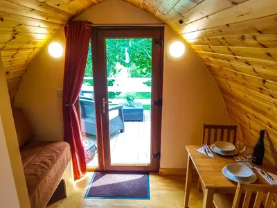 a small room with a table and a door to a patio at Colemans Cottage Fishery in Wickham Bishops