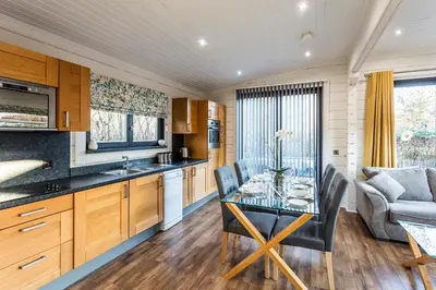 a kitchen and dining room with a table and chairs at Roydon Marina Village Lodges in Roydon