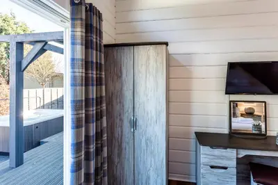 a room with a sliding door to a deck with a television at Roydon Marina Village Lodges in Roydon