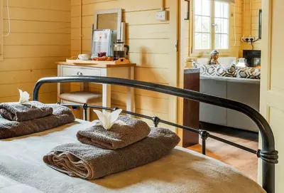 a bedroom with a bed with towels on it at Sunset log cabin in Sudbury