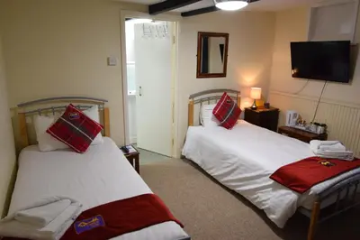 a hotel room with two beds and a television at Castle Lodge in Ely