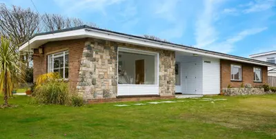 a brick house with a white garage at Invershin -Aldeburgh Coastal Cottages in Thorpeness