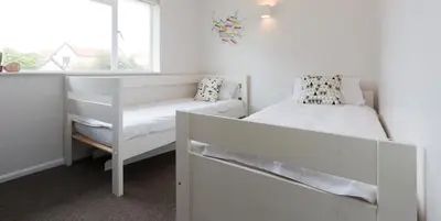 a white bedroom with a bed and a window at Invershin -Aldeburgh Coastal Cottages in Thorpeness