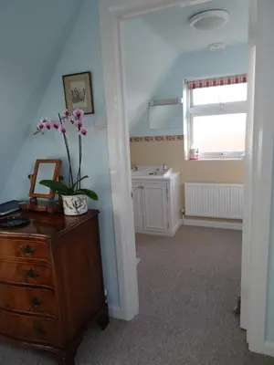 a room with a dresser with a flower on it at The Newnham White House in Baldock