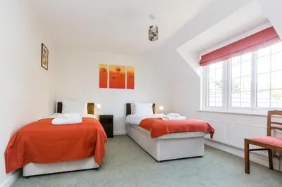a white room with two beds and a window at Lake Cottage - A large holiday home in Thorpeness - Close to the beach and The Meare - Aldeburgh Coastal Cottages in Thorpeness
