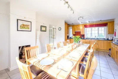 a dining room with a long table and chairs at Lake Cottage - A large holiday home in Thorpeness - Close to the beach and The Meare - Aldeburgh Coastal Cottages in Thorpeness