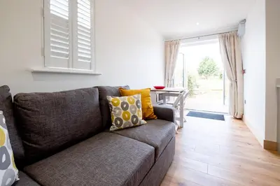 a living room with a couch and a table at Oak - Three Tuns Apartments, Pettistree, Wickham Market - by Aldeburgh Coastal Cottages in Pettistree