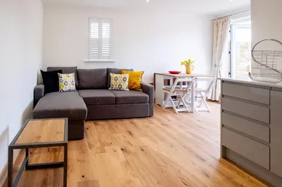 a living room with a couch and a table at Oak - Three Tuns Apartments, Pettistree, Wickham Market - by Aldeburgh Coastal Cottages in Pettistree
