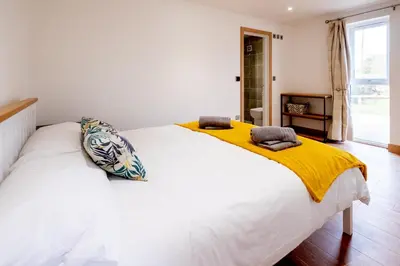 a bedroom with a white bed with a yellow blanket on it at Maple - Three Tuns Apartments - Pettistree, Wickham Market - by Aldeburgh Coastal Cottages in Pettistree