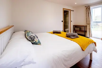 a bedroom with a large white bed with yellow sheets at Maple - Three Tuns Apartments - Pettistree, Wickham Market - by Aldeburgh Coastal Cottages in Pettistree