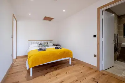 a bedroom with a bed with a yellow blanket at Maple - Three Tuns Apartments - Pettistree, Wickham Market - by Aldeburgh Coastal Cottages in Pettistree