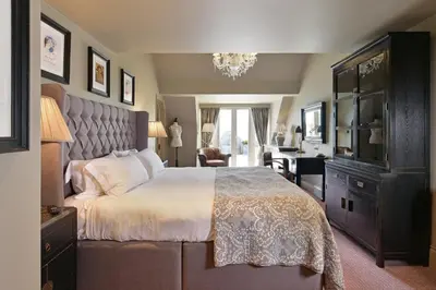 a bedroom with a large bed and a desk at The Lion Inn in Chelmsford
