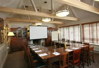 a conference room with a long table and a screen at The Lion Inn in Chelmsford