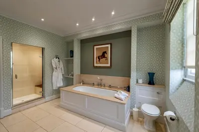 a bathroom with a tub and a shower and a toilet at The Jockey Club Rooms in Newmarket