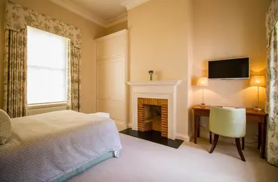 a bedroom with a bed and a fireplace at The Jockey Club Rooms in Newmarket