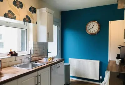 a kitchen with a clock on a blue wall at The Avenues in Chelmsford