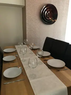 a wooden table with plates and wine glasses on it at The Avenues in Chelmsford