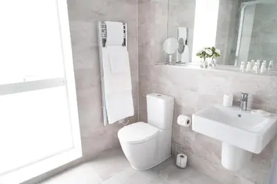 a bathroom with a toilet and a sink and a mirror at Citystay Living - Park House in Cambridge