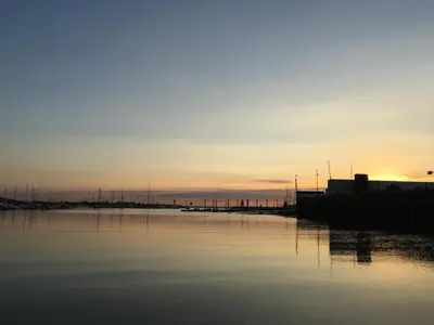 a body of water with a sunset in the background at Wayside Cottage in Saint Osyth
