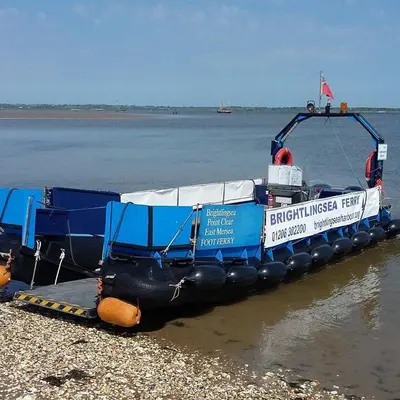 a blue boat is sitting on the shore at Wayside Cottage in Saint Osyth