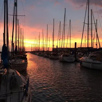 a group of boats docked in a harbor at sunset at Wayside Cottage in Saint Osyth