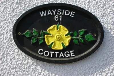 a black and yellow badge with the words wayside coffee at Wayside Cottage in Saint Osyth