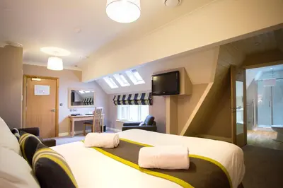 a hotel room with a large bed and a living room at Breckland Lodge in Attleborough