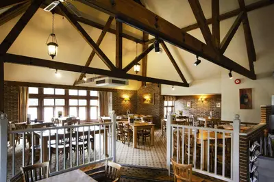 a restaurant with tables and chairs in a room at Breckland Lodge in Attleborough
