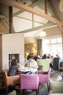 a group of people sitting at tables in a restaurant at Breckland Lodge in Attleborough