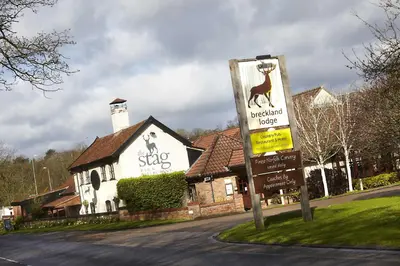 a sign in front of a building with a deer sign at Breckland Lodge in Attleborough