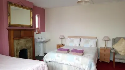 a bedroom with a bed and a mirror and a fireplace at Kingsway Bed & Breakfast in Broxbourne