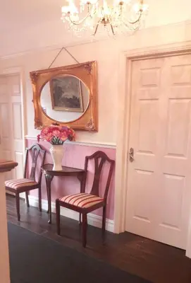 a dining room with a table and two chairs and a mirror at Kingsway Bed & Breakfast in Broxbourne