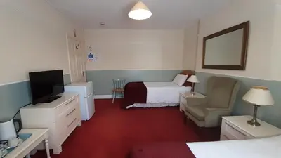 a hotel room with a bedroom with a bed and a television at Kingsway Bed & Breakfast in Broxbourne