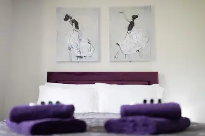 a bedroom with a bed with two pictures on the wall at The Norna in Cambridge